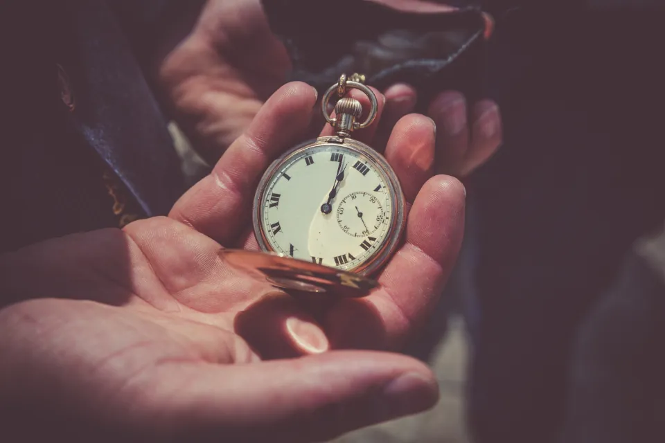 Deux mains ouvertes qui tiennent une montre à gousset.
