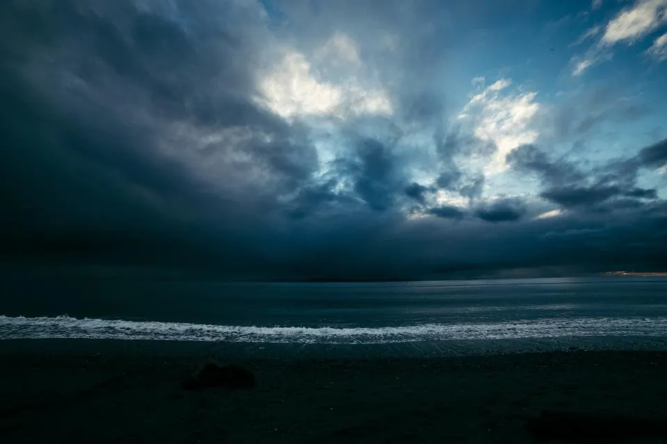 Mer sombre sous un ciel d'orage chargé de nuages.