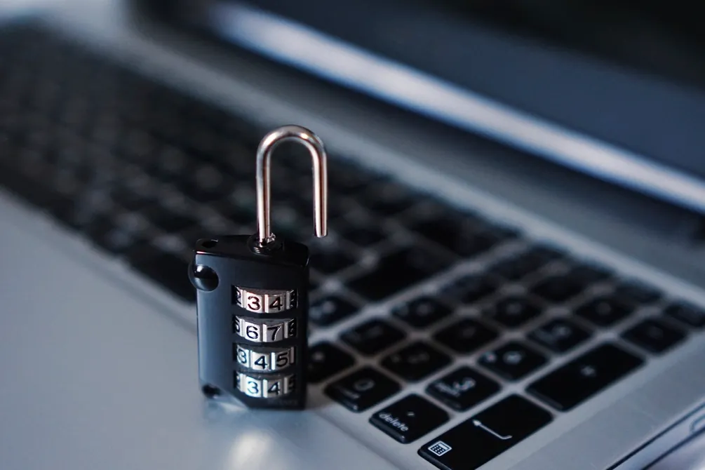 Cadenas à combinaison posé sur le clavier d'un ordinateur portable.