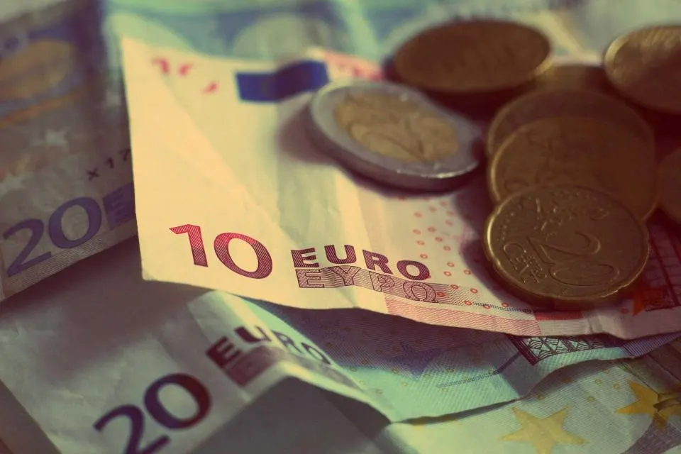 Billets de 10 et 20 euros recouverts de pièces de monnaie.
